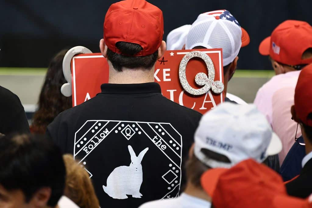 Members of QAnon await the arrival of US President Donald Trump for a political rally at Mohegan Sun Arena in Wilkes-Barre, Pennsylvania on August 2, 2018.
