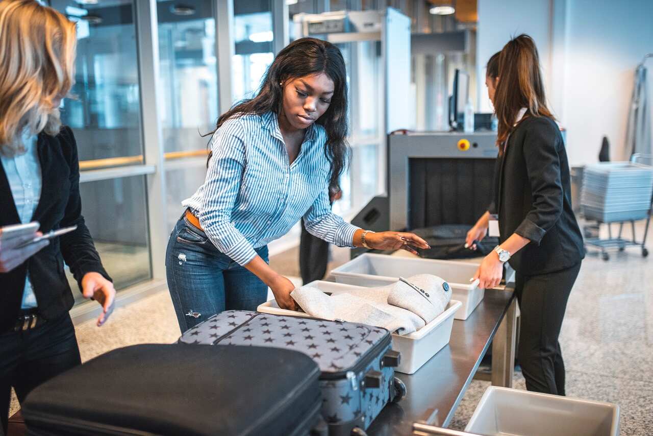 Passengers go through airport security.