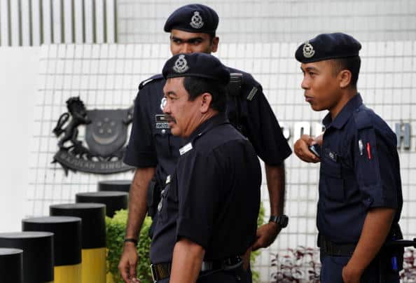 Malaysian police stand guard as anti-death penalty activists protest in Kuala Lumpur.