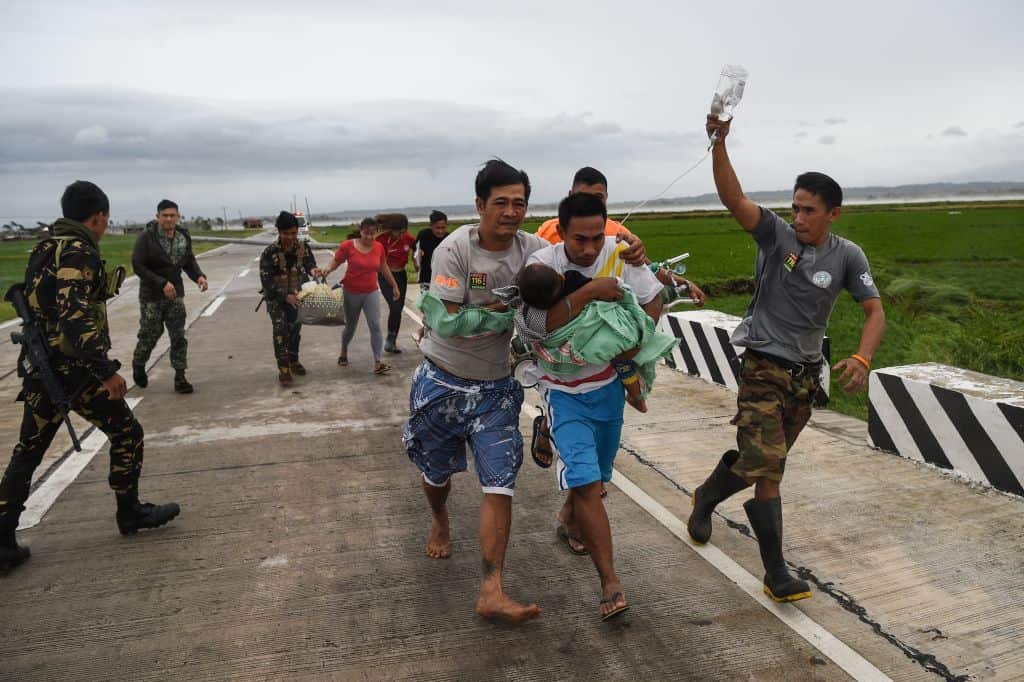 Philippine soldiers assist a family carrying their sick child 