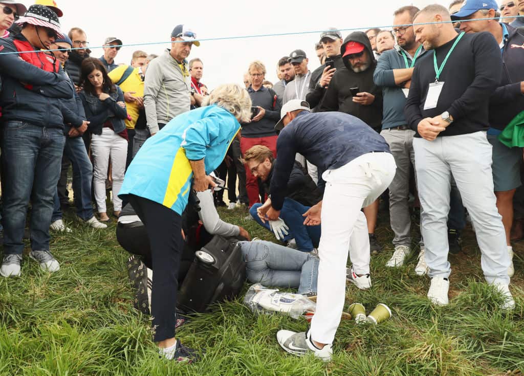 Brooks Koepka signs a glove and gives it to the woman who was hit by the ball during the Ryder Cup.