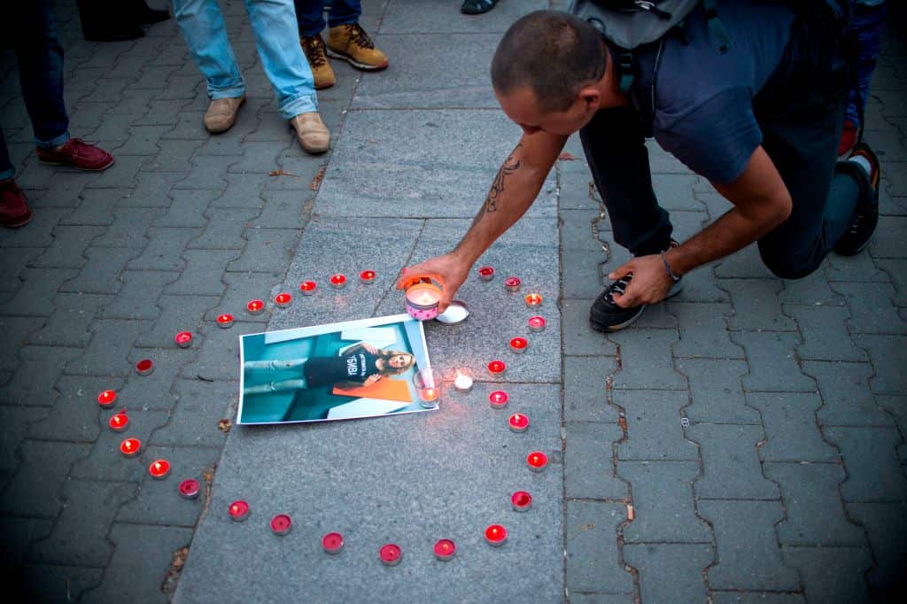 A man lights a candle during a vigil in memory of murdered Bulgarian TV journalist Viktoria Marinova in Sofia.