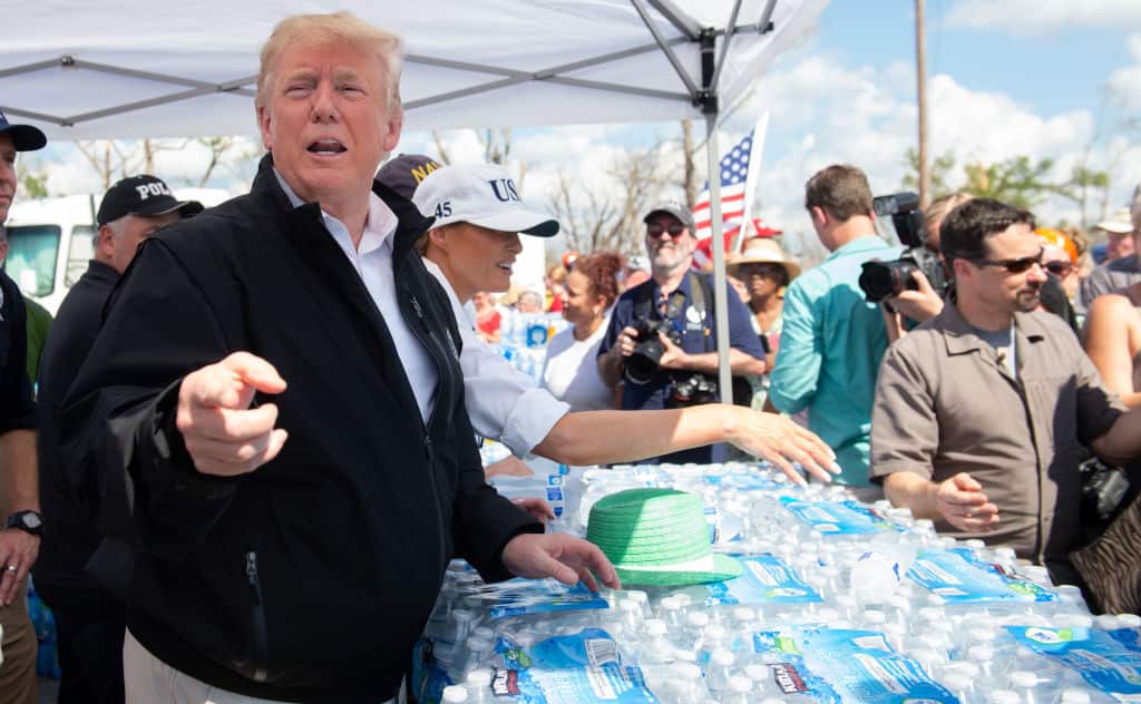 US President Donald Trump and First Lady Melania Trump hand out bottles of water as they tour damage from Hurricane Michael in Lynn Haven, Florida.