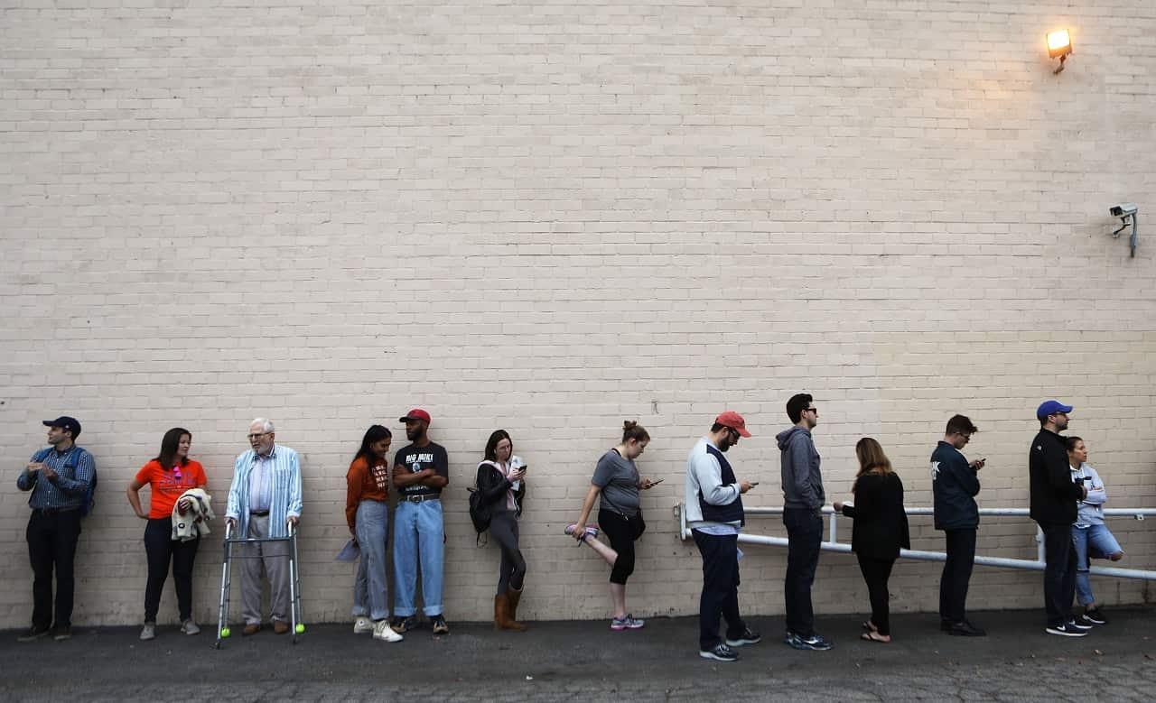 Voters wait in line for polls to open on Tuesday morning.