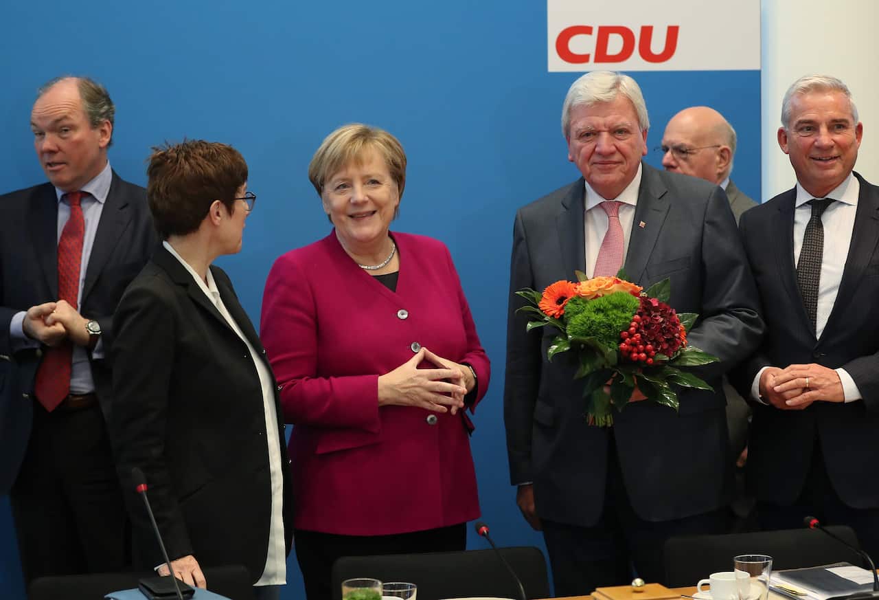 German Chancellor Angela Merkel stands with Annegret Kramp-Karrenbauer and Volker Bouffier.