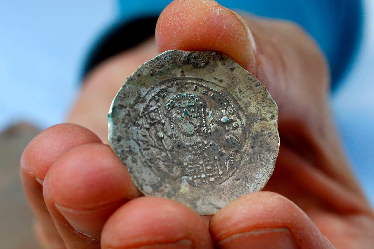 Ancient gold coins and an earring recently uncovered at an excavation site in the Israeli Mediterranean town of Caesarea.
