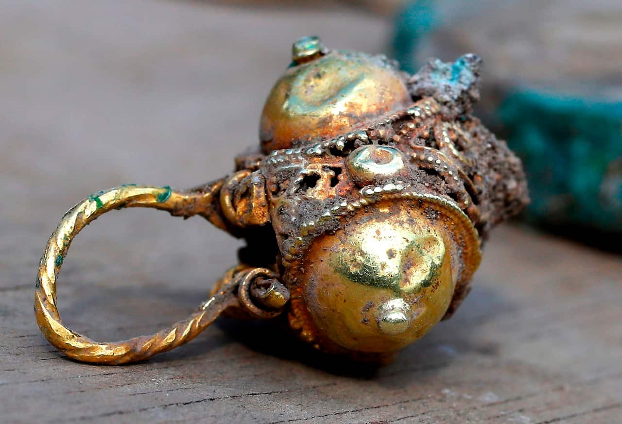 Ancient gold coins and an earring recently uncovered at an excavation site in the Israeli Mediterranean town of Caesarea.