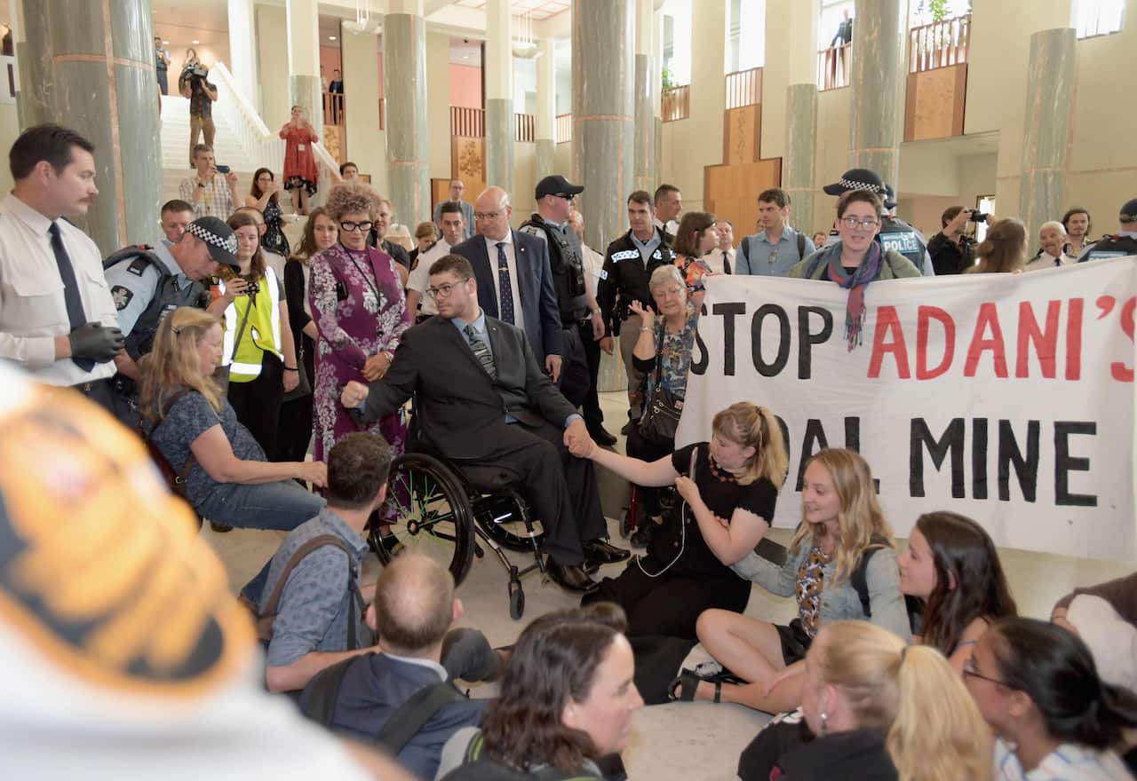 Jordon Steele-John with demonstrators at Parliament House in Canberra. 