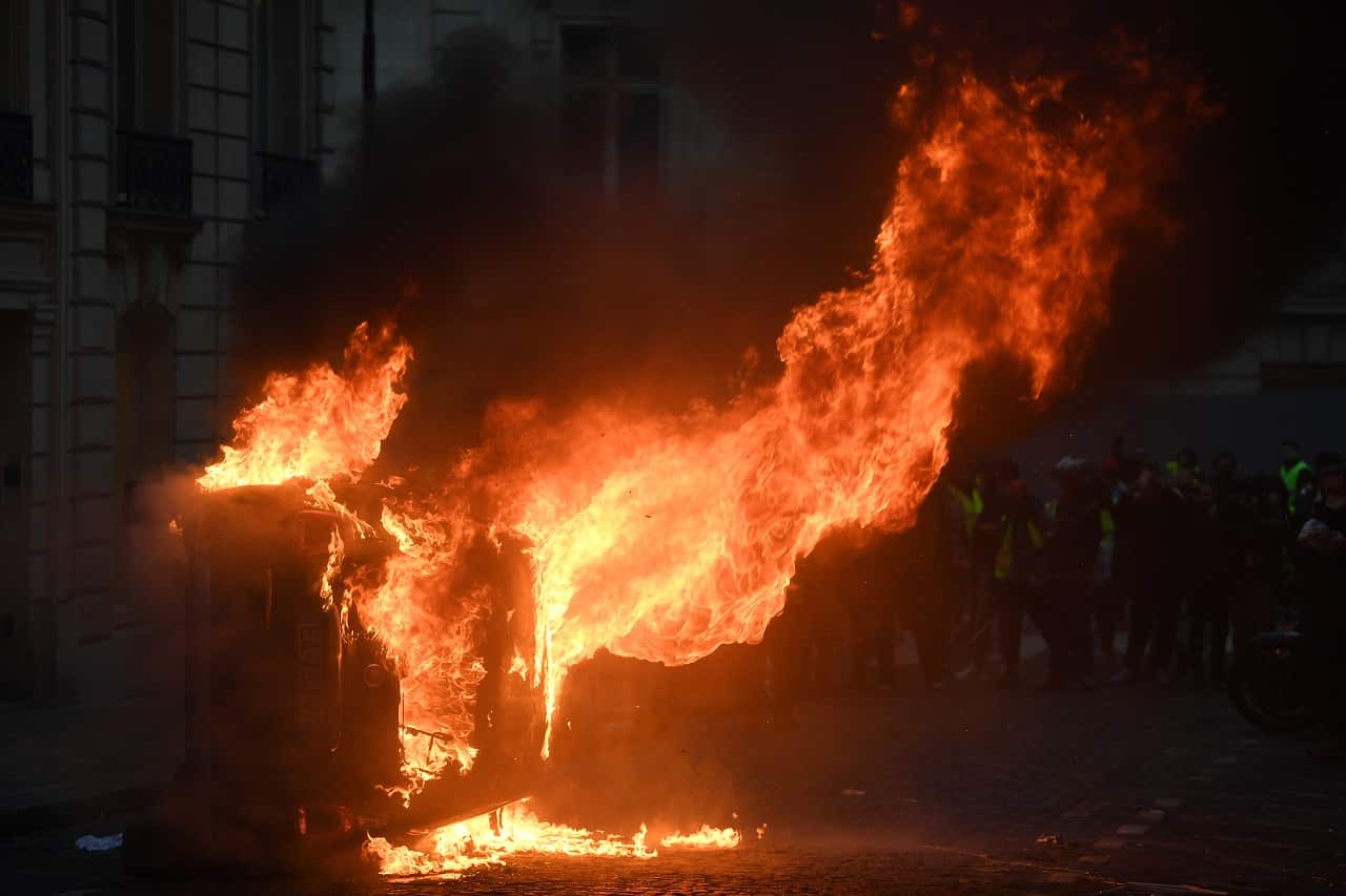 A vehicle is set on fire as protesters take part in the 'yellow vests' demonstration in Paris.
