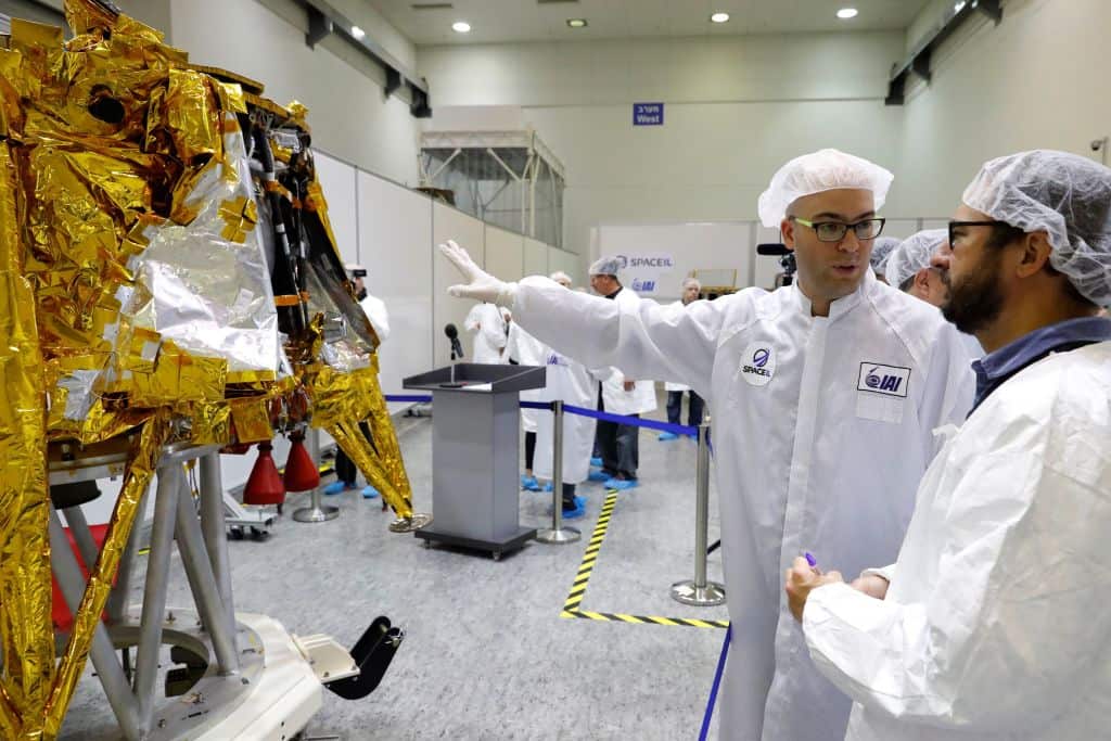 Scientists stand next to the spacecraft.