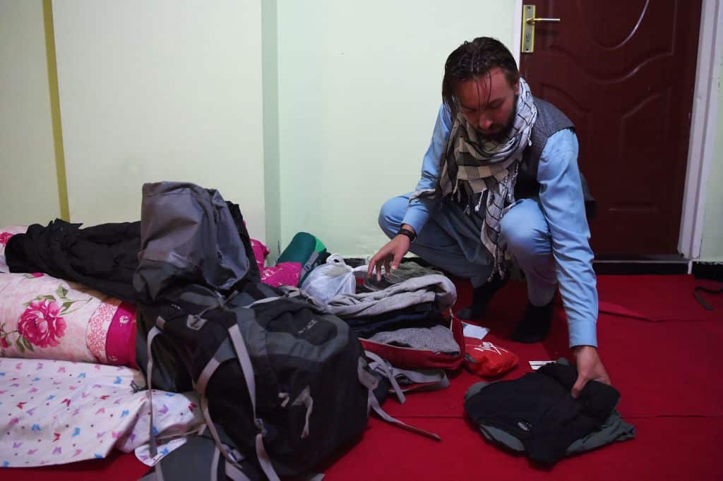 Dutch tourist Ciaran Barr, 24, arranges his clothes as he is hosted by Afghan Couchsurfing host Naser Majidi at a house in Kabul.