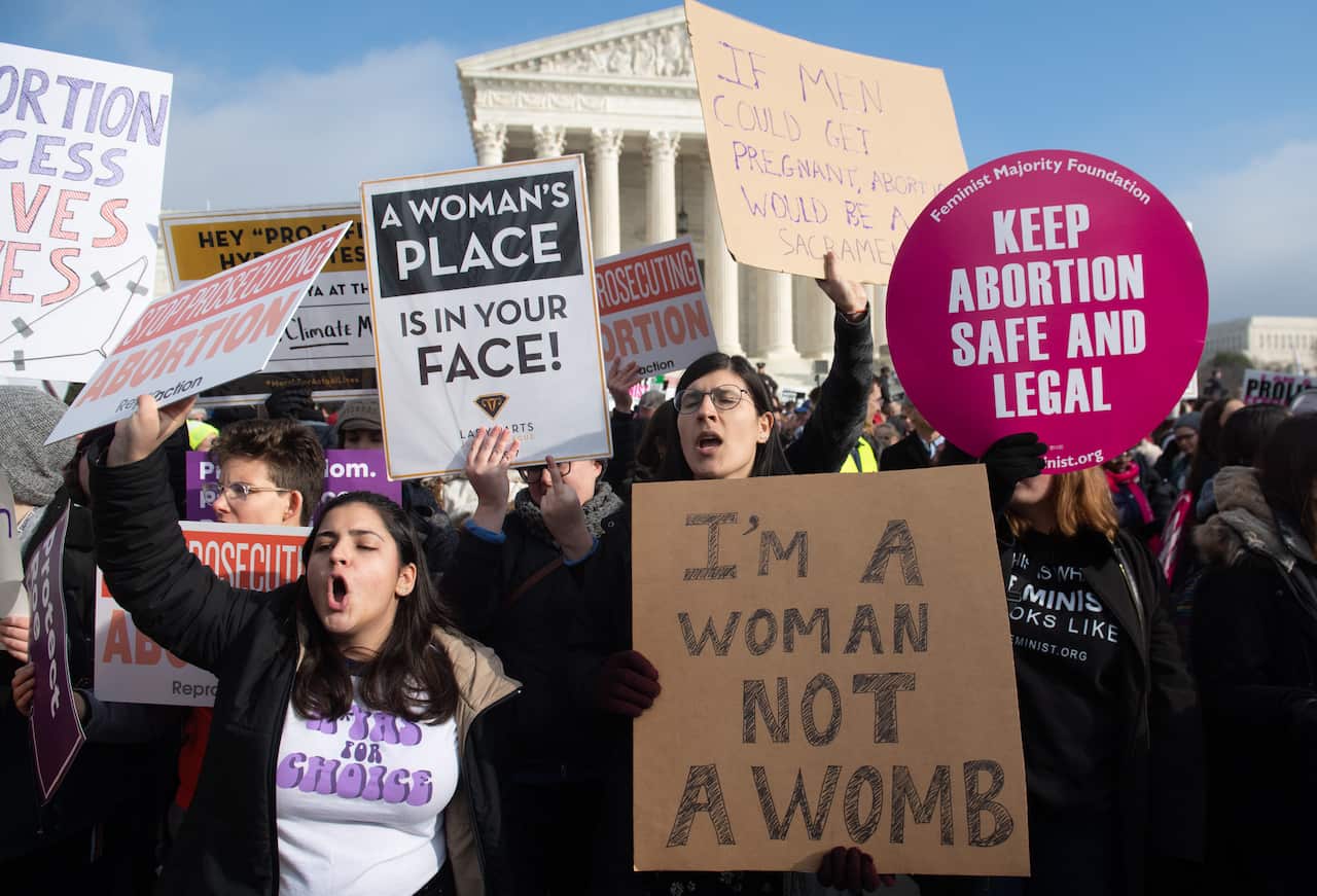 Pro-choice activists hold signs in response to anti-abortion activists participating in the "March for Life", January 2019.