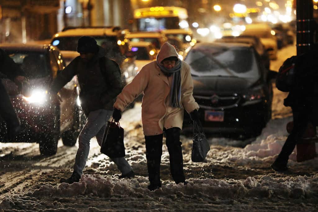 Pedestrians contend with snow and cold weather in Chicago on Monday.