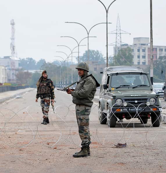Army personnel stand guard during a curfew on 17 February in Jammu, India. 