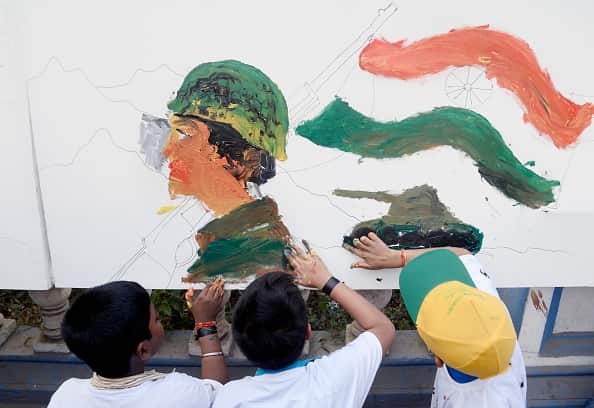 Children paint a canvas to pay tribute to the soldiers who died in the Kashmir attack. 