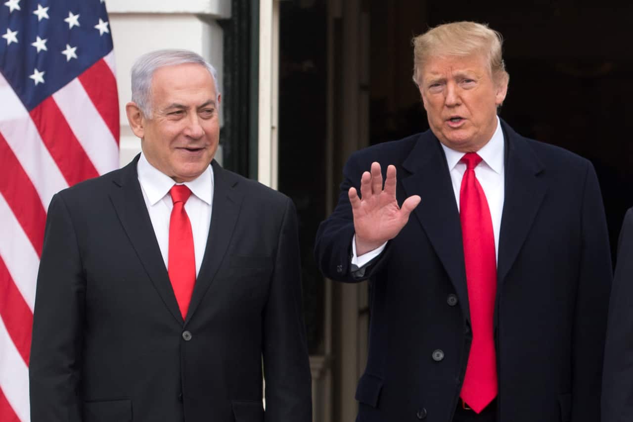 US President Donald J. Trump (R) waves beside Prime Minister of Israel Benjamin Netanyahu (L).