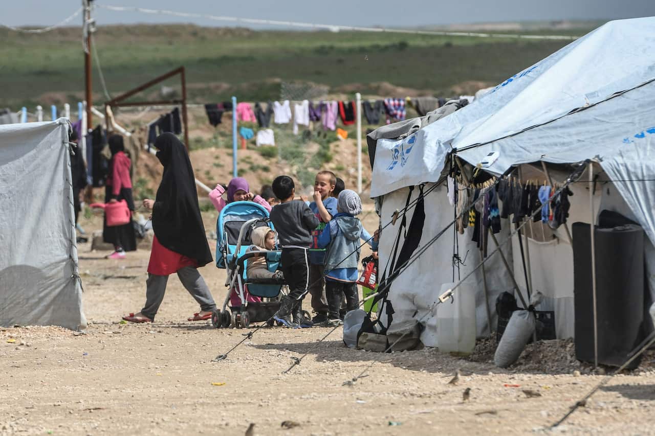 Children gather inside the Al-Hawl camp which houses relatives of Islamic State (IS) group members.
