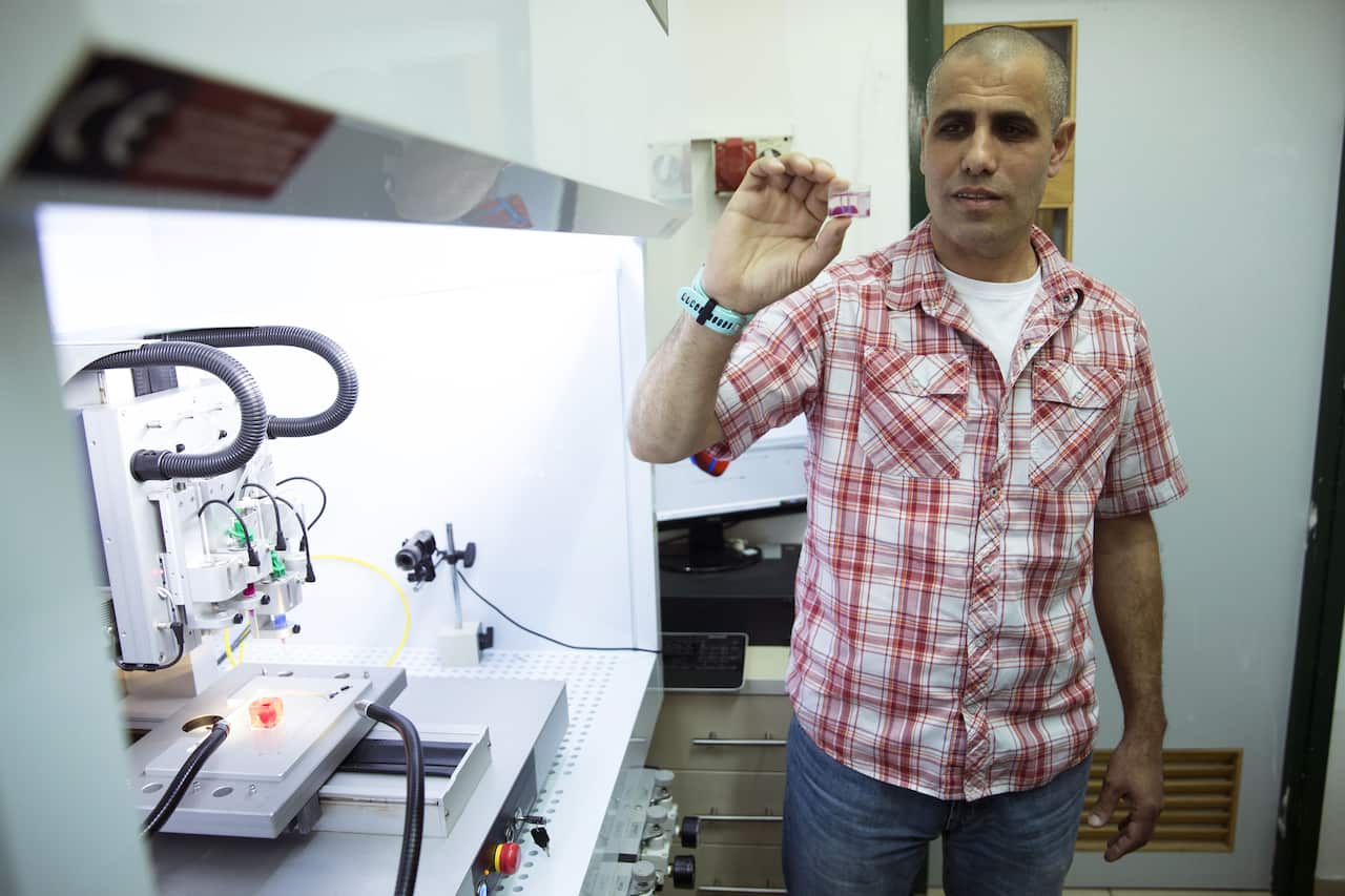 Professor Tal Dvir presents a 3D-printed heart made from human tissue in his laboratory.