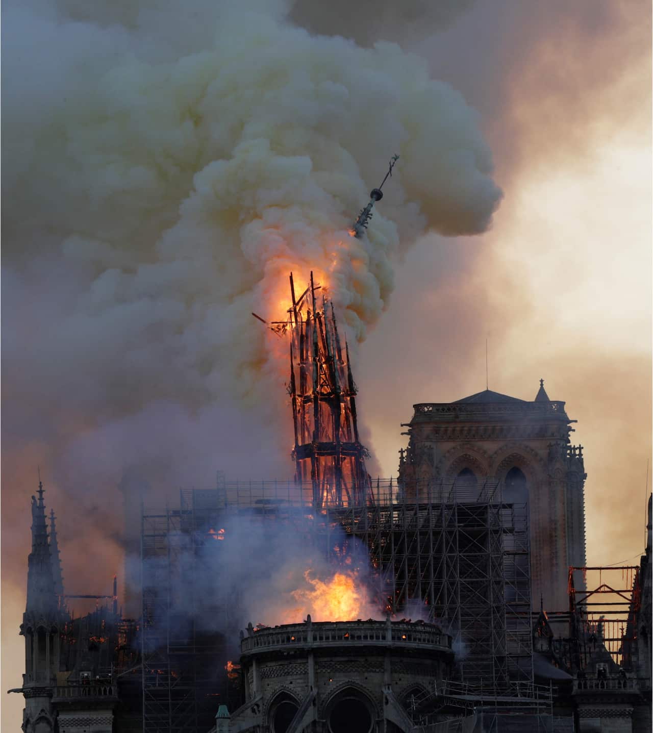 The steeple engulfed in flames collapses as the roof of the Notre-Dame de Paris Cathedral burns.