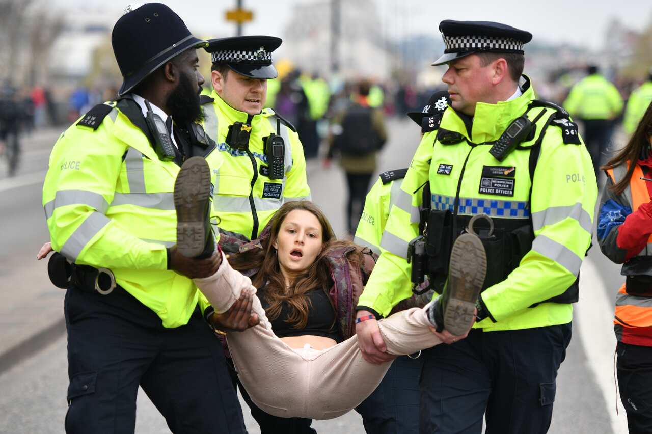 Police officers remove protesters from a blockade on Waterloo Bridge.