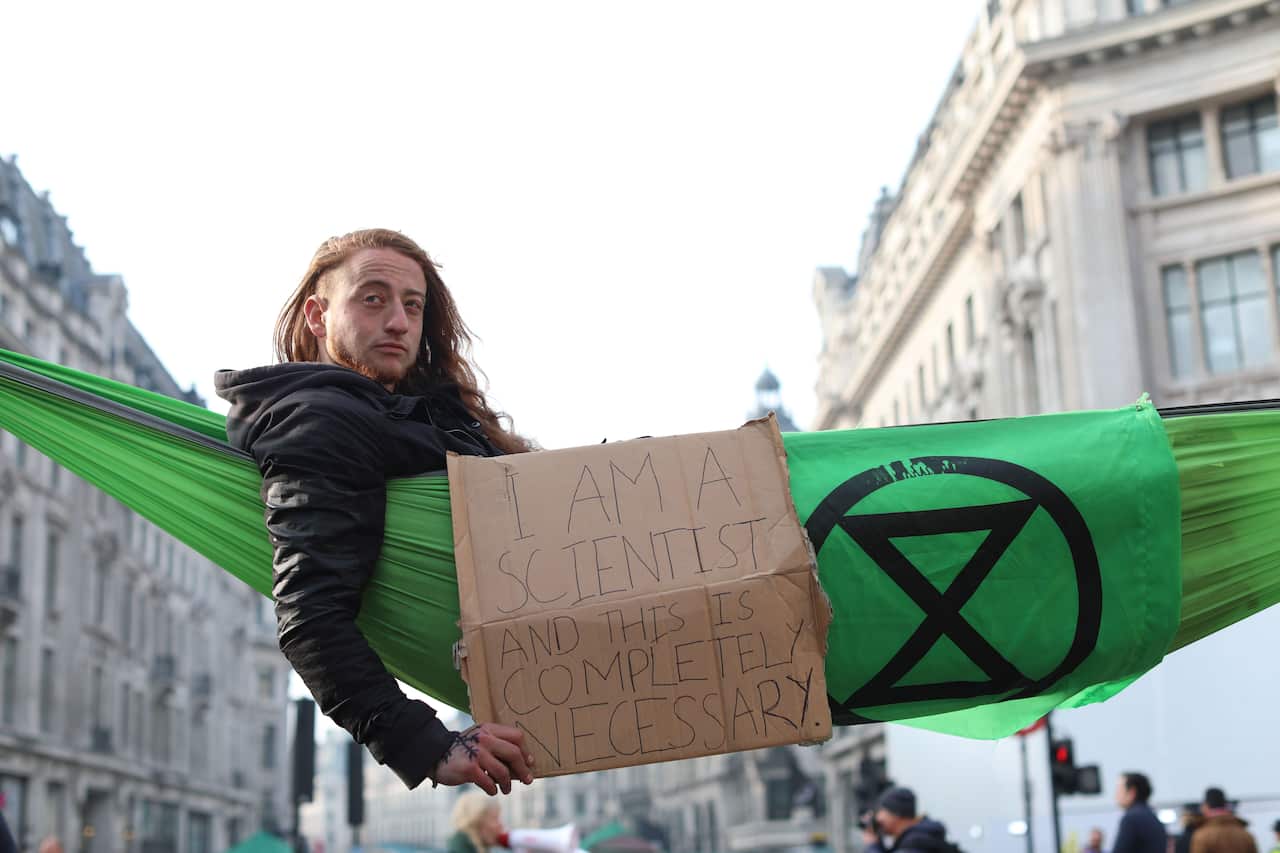 A cimate change activist poses in a hammock in the busy shopping district of central London.