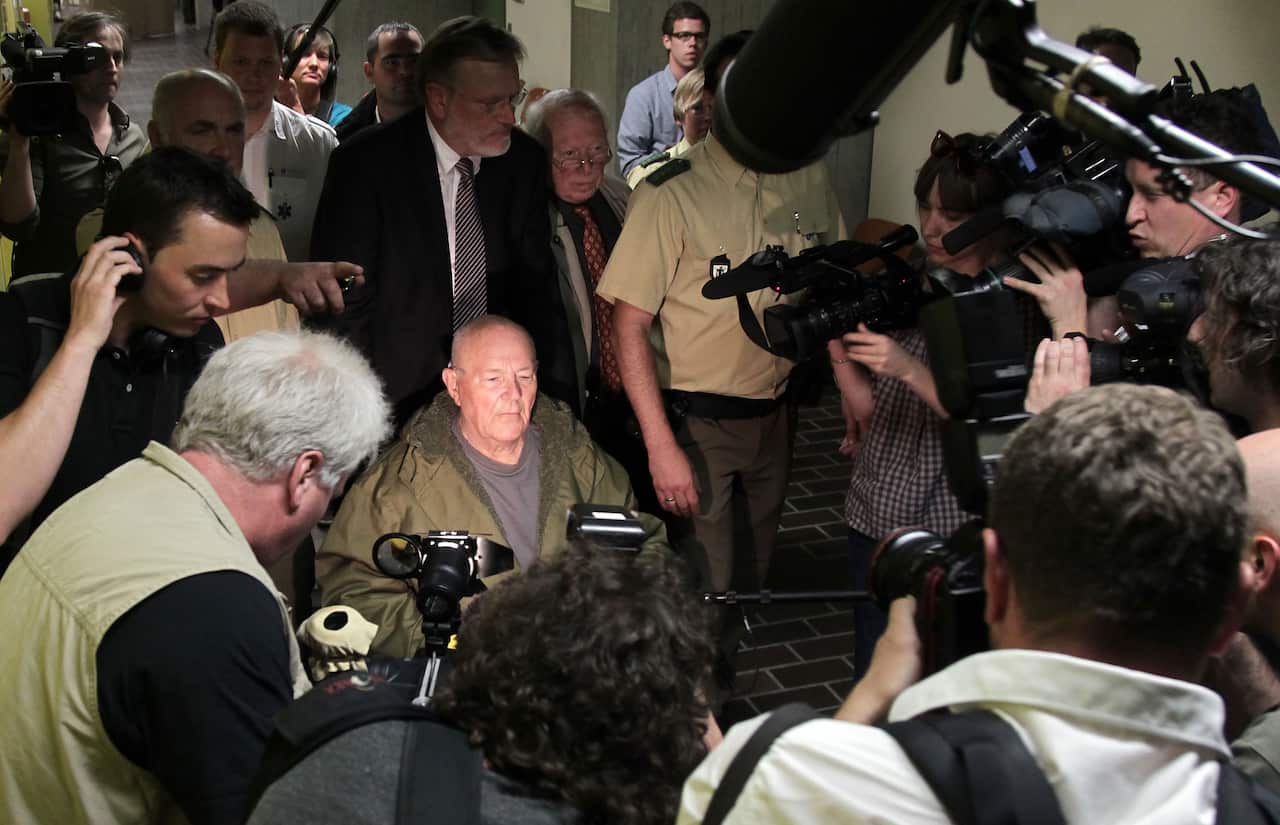 John Demjanjuk and his lawyers emerge from a Munich court in 2011 after a judge sentenced him to 5 years in prison.