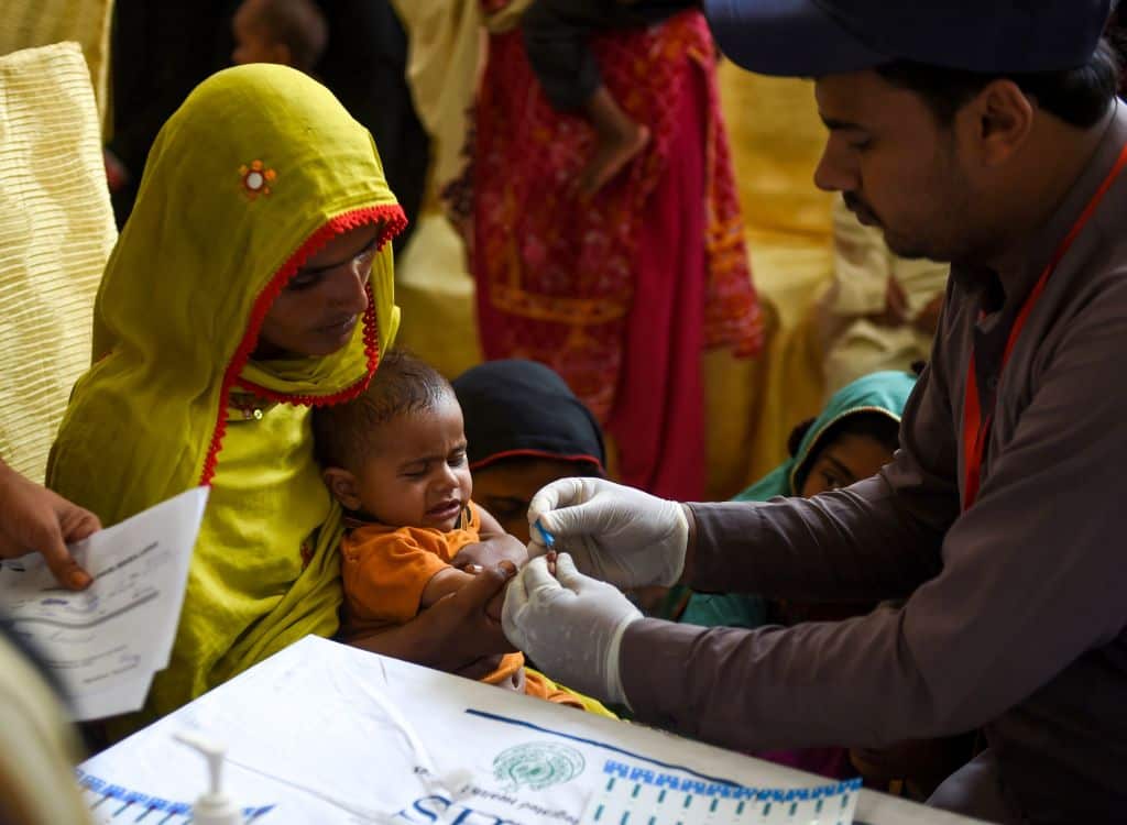 A paramedic takes a blood sample from a baby for a HIV test.