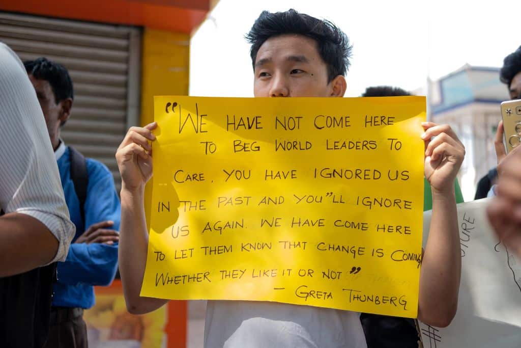 A student holds a placard as he participates in a global strike for urgent climate action in New Delhi.