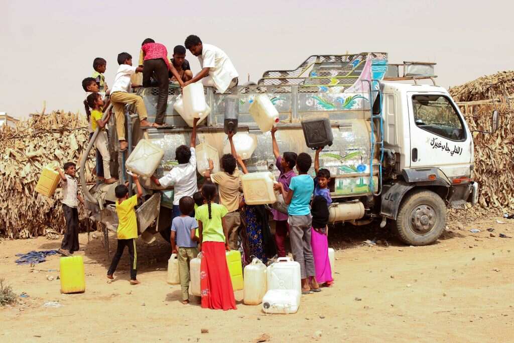 TOPSHODisplaced Yemenis from Hodeida fill jerrycans with water at a make-shift camp.