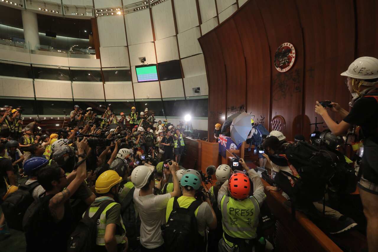 Protesters tie the British colonial flag to the parliament podium.