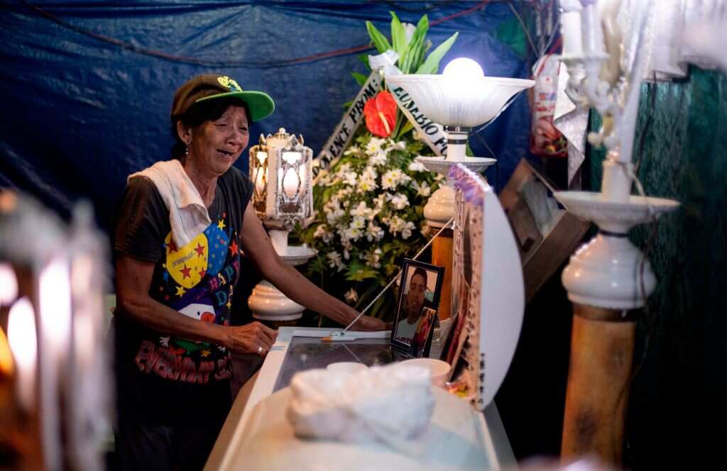 A woman cries at the wake of her grandson.