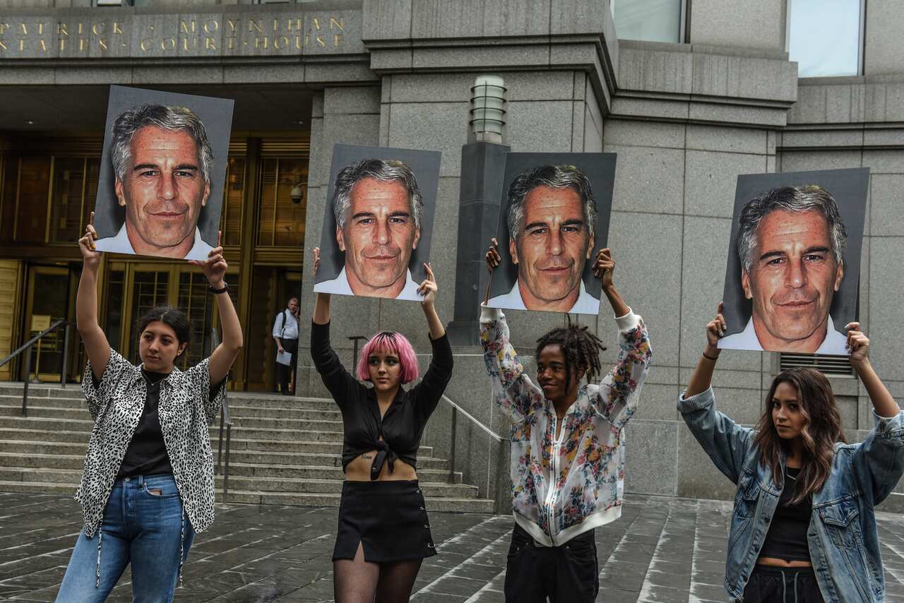A protest group called "Hot Mess" hold up signs of Jeffrey Epstein in front of the Federal courthouse on July 8, 2019 in New York City