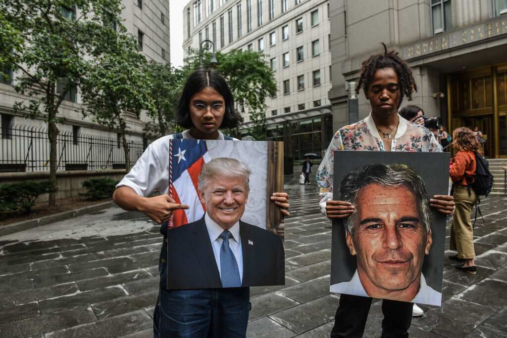 Protesters hold up signs of Jeffrey Epstein and US President Donald Trump in front of the Federal courthouse.