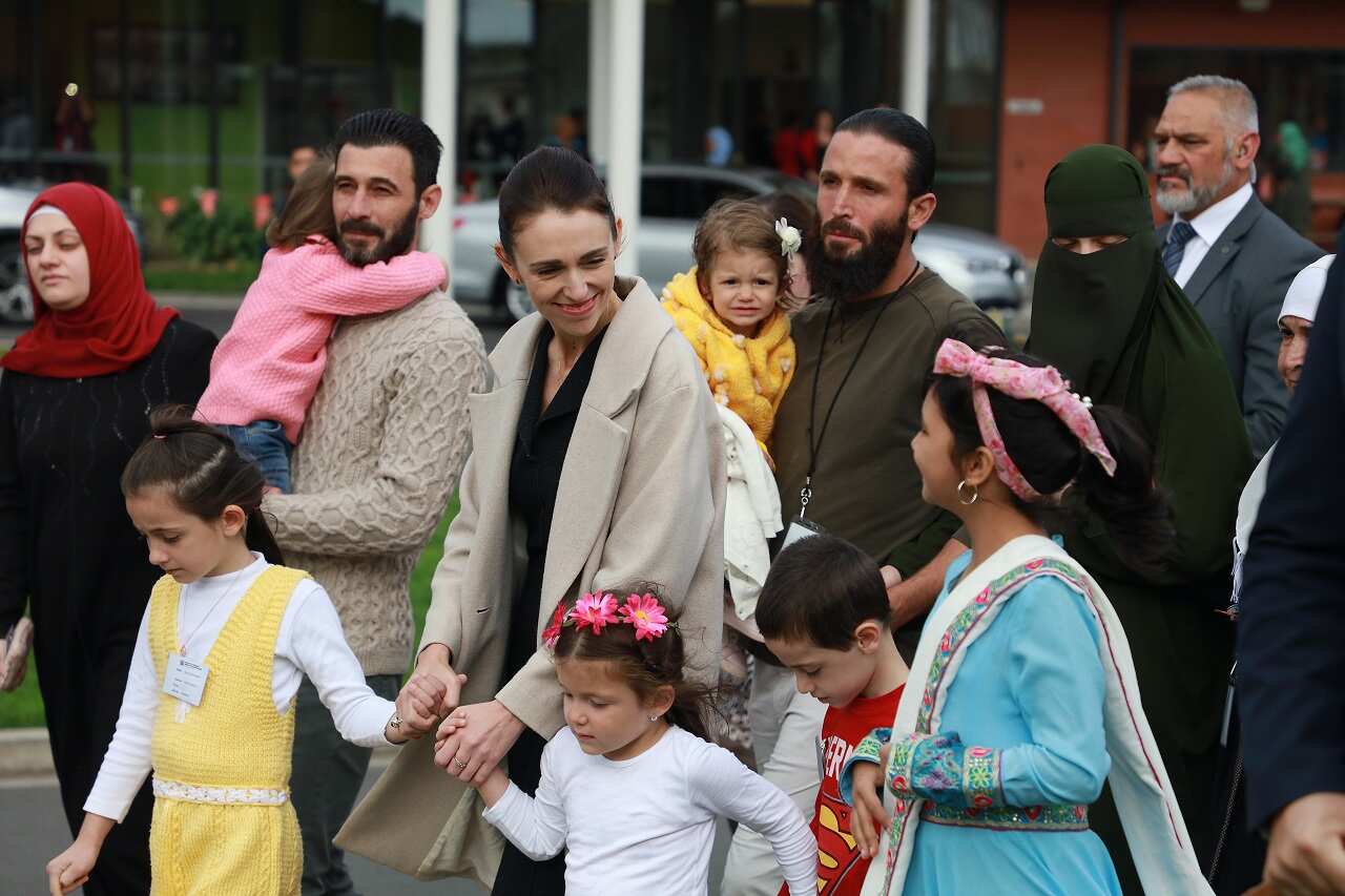 Jacinda Ardern walks to plant a tree of remembrance with people connected to the Christchurch terror attacks. NZ has been urged to take more refugees. 
