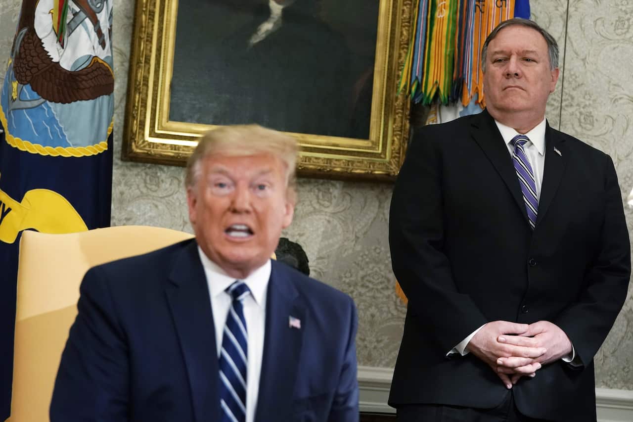 Secretary of State Mike Pompeo looks on as President Donald Trump speaks  in the Oval Office of the White House.