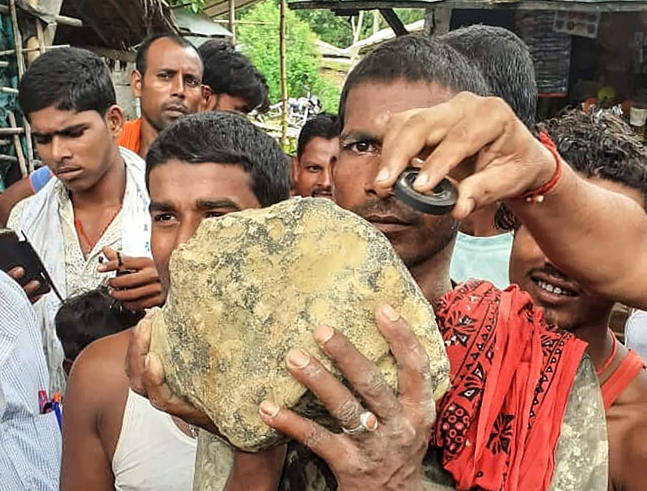 A villager holds the suspected meteorite.