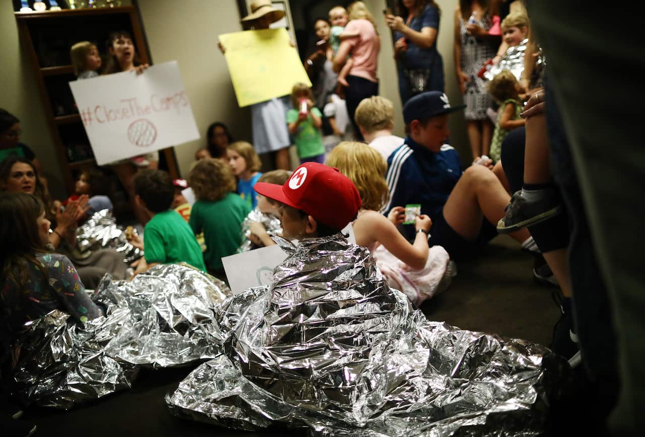 Protesters with children dressed in Mylar blankets demonstrate at a 'playdate protest', calling for the closing of detention centers for migrant children.