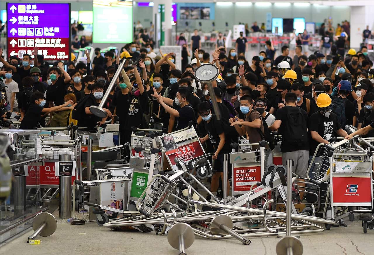 Pro-democracy protestors block the entrance to the airport terminals after a scuffle with police at Hong Kong's international airport.