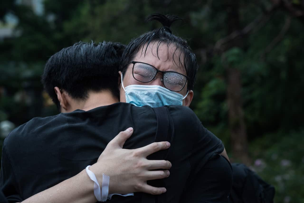 A protester cries as another activist embraces him during demonstrations.
