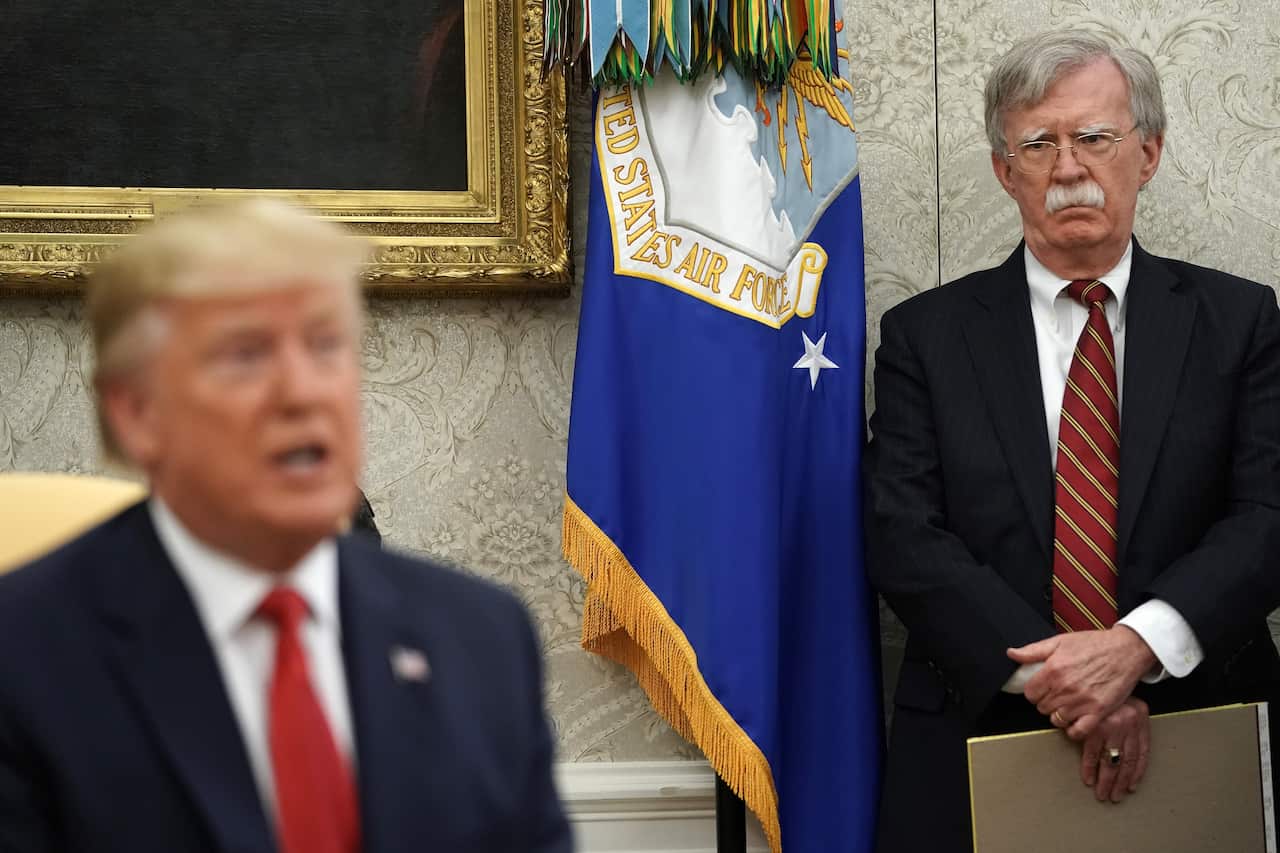 Former White House National Security Advisor John Bolton (R) listens to U.S. President Donald Trump.