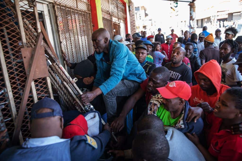 Looters try to break into an alleged foreign-owned shop during a riot in the Johannesburg suburb of Turffontein on September 2