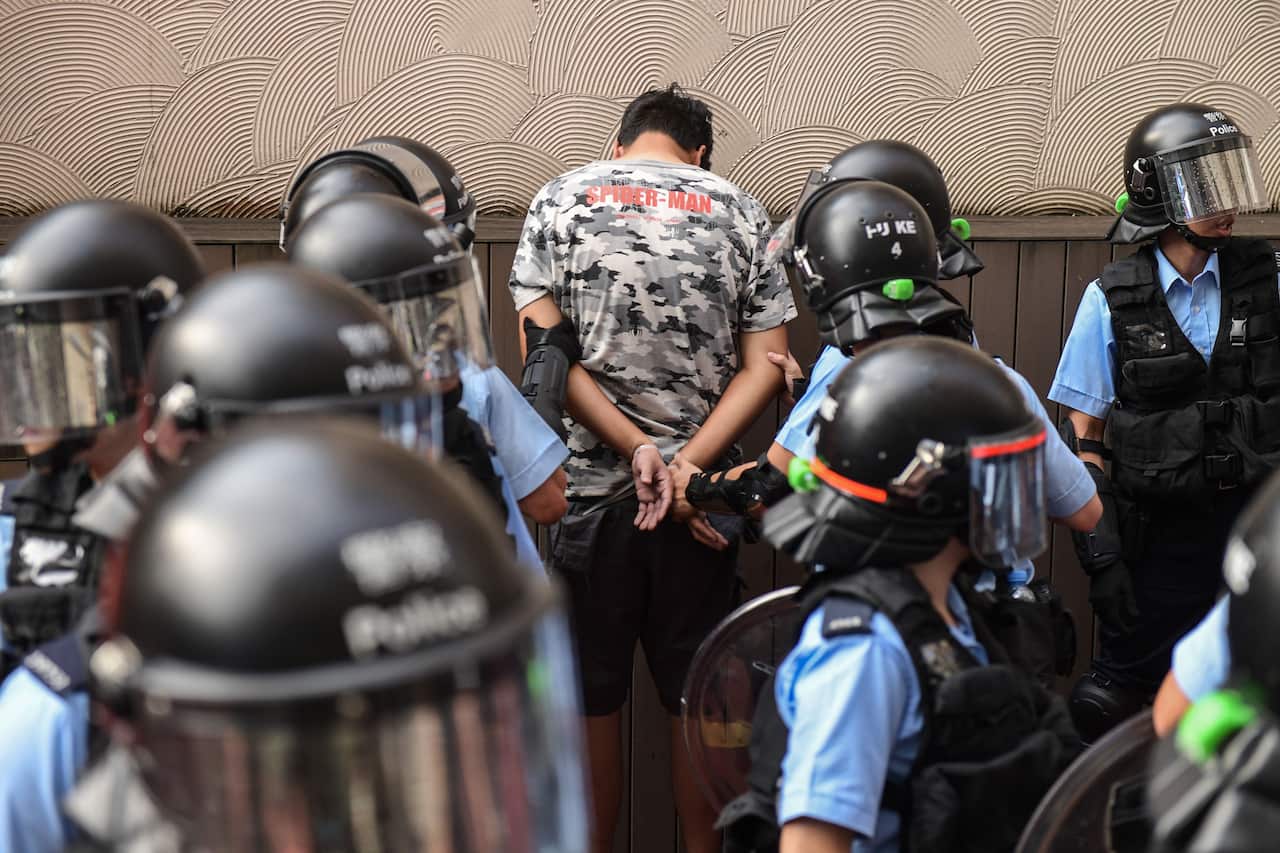 Police detain a man after fights broke out between pro-China supporters and anti-government protesters at Amoy Plaza.