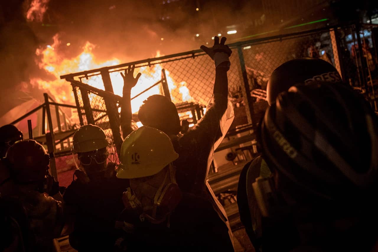 Protesters celebrate after setting fire to a makeshift barricade on Saturday.