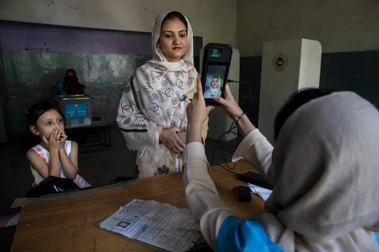 An Afghan woman has her photo taken as part of the voting process.