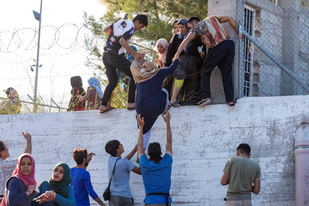 TOPSHOT - Refugees and migrants try to escape the camp of Moria after a fire broke out in the camp in Mytilene on September 29, 2019. (Photo by SOLVIE IREN WESSEL-BERG / AFP)        (Photo credit should read SOLVIE IREN WESSEL-BERG/AFP/Getty Images)
