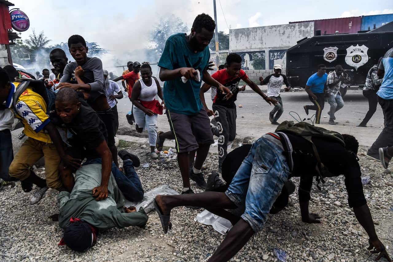 Demonstrators run as police open fire during a protest.