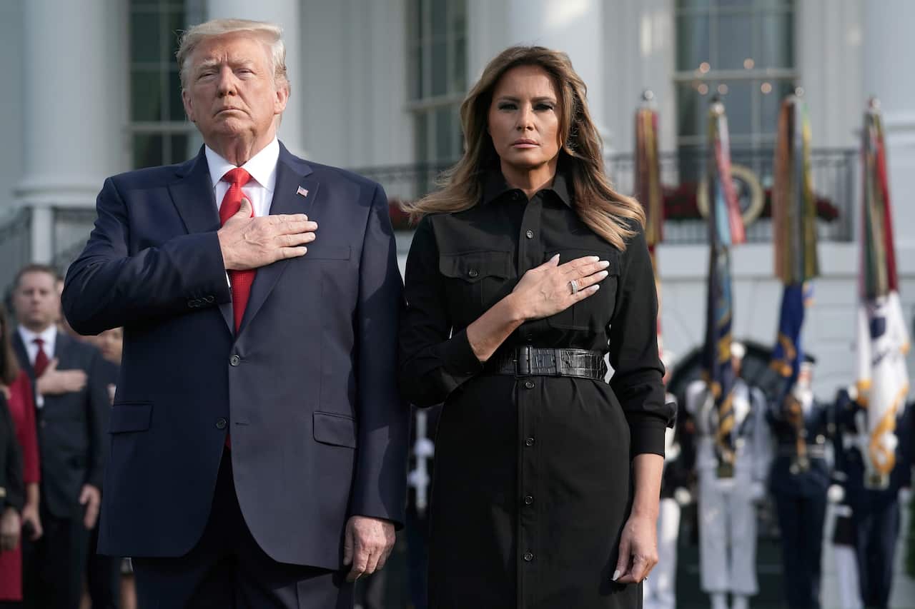 US President Donald Trump and first lady Melania Trump are joined by survivors, victim's families and staff as they participate in a moment of silence.