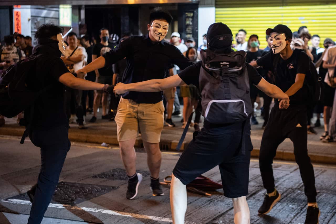 Masked protesters dance near Mong Kok Police Station.