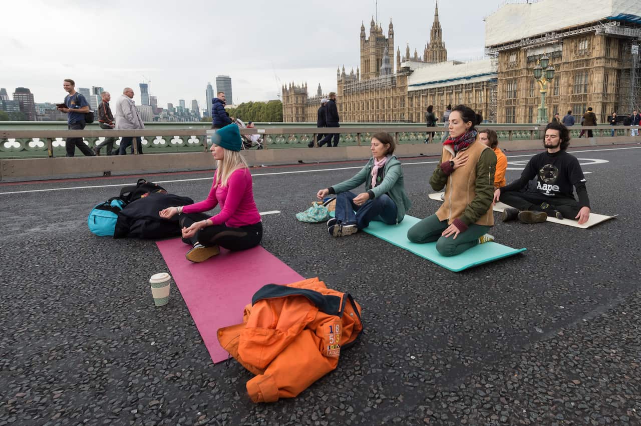 Environmental activists from Extinction Rebellion meditate during a protest at Westminster Bridge.