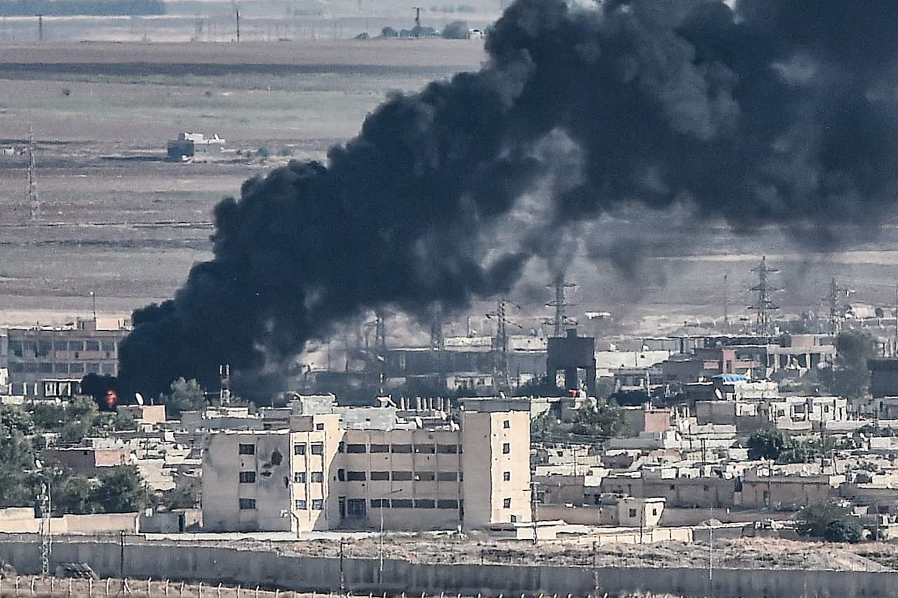 Smoke is seen rising from the Syrian border town of Ras al-Ain as fighting rages along the border.